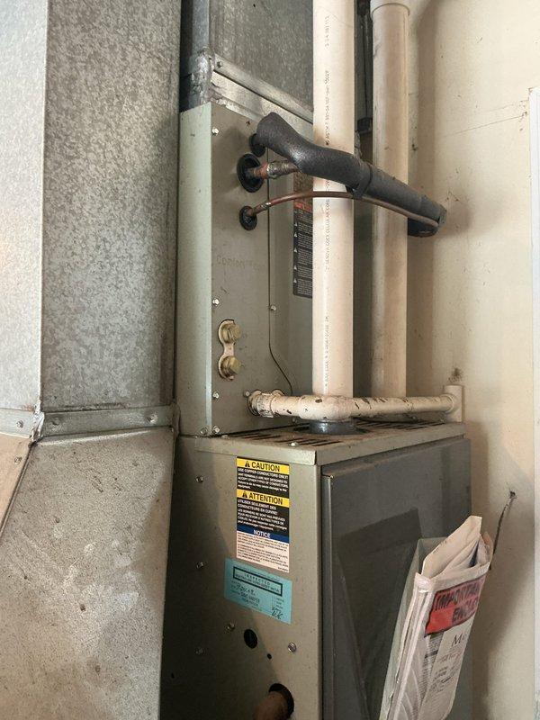 Completed comprehensive HVAC system replacement estimate for residential property. Assessed existing outdoor condensing unit positioned in landscaped area with adequate clearance concerns due to surrounding vegetation, and evaluated indoor furnace system located in basement utility room showing signs of age and wear. Documented current equipment specifications, electrical connections including disconnect box and meter configuration, refrigerant line routing, condensate drainage system, and ductwork connections to provide accurate replacement recommendations for complete system upgrade.