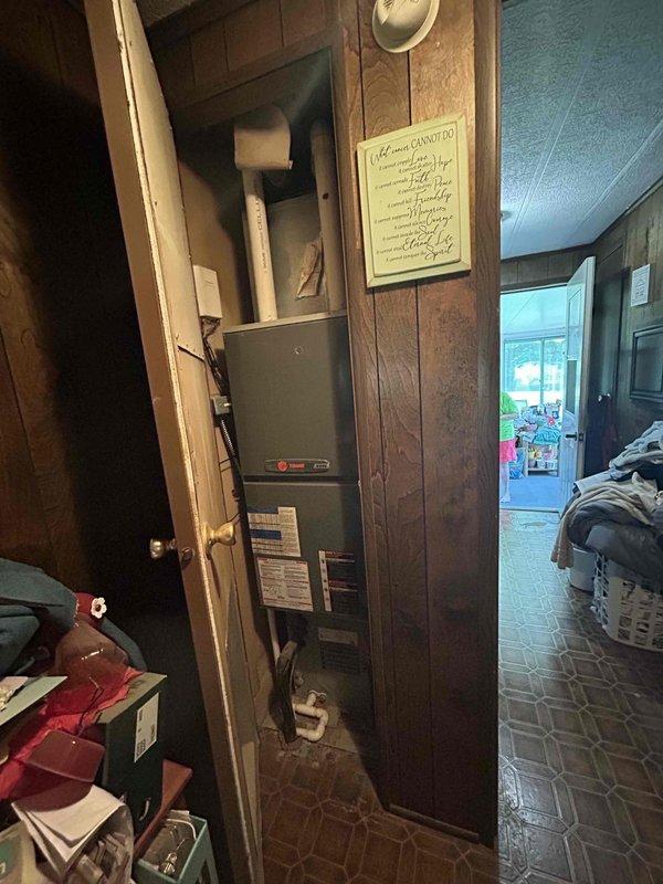 Responded to service call for non-functional outdoor HVAC unit with failed compressor. Conducted thorough assessment of existing system located in confined exterior space between building wall and window, noting significant age-related deterioration, weathering, and debris accumulation around unit. Evaluated indoor furnace component housed in utility closet to determine compatibility requirements for replacement system. Documented current equipment condition through photographs and prepared comprehensive estimate for complete system replacement due to compressor failure rendering existing unit beyond economical repair.