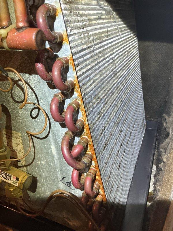 Completed first prepaid cooling maintenance visit on residential HVAC system. Performed comprehensive inspection of evaporator coil assembly, heat exchanger components, and ductwork connections in indoor unit. Documented system condition with photos showing aluminum fin coil with copper refrigerant lines, brass fittings, and ductwork junction points; noted age-related oxidation on copper tubing and minor corrosion on unit frame consistent with normal wear, but all components remain functional and system is operating within normal parameters.