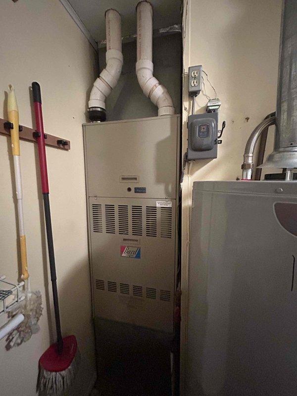 Conducted on-site assessment for complete HVAC system replacement including gas furnace and air conditioning unit. Evaluated existing furnace installation in basement utility room, noting current configuration with PVC exhaust and intake venting system. Inspected outdoor condensing unit positioned on exterior pad against home's foundation. Documented equipment specifications, dimensions, and existing infrastructure including electrical service, gas connections, and ductwork routing to provide accurate replacement quote for both heating and cooling systems.