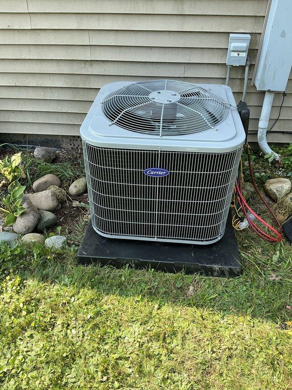Completed half-system replacement installation of Carrier Comfort Series 26SCA436N003 single-stage air conditioner with matching Carrier CVAVA4217XMA evaporator coil. Removed and recycled existing outdoor condensing unit and indoor coil, then installed new equipment utilizing existing supply and return ductwork in indoor utility area. Reconnected to existing refrigerant line set after performing complete flush and pressure test to ensure system integrity. Installed new outdoor condensing unit on 2-inch PVC pad with pea gravel base for proper drainage and leveling, mounted new electrical disconnect box and whip for code-compliant power supply. Completed all refrigerant connections, performed leak test, evacuated system, and charged to manufacturer specifications. Verified proper airflow, temperature split, and operational performance of single-stage cooling system. Registered manufacturer warranty coverage for both air conditioner and evaporator coil providing 10-year limited parts prot