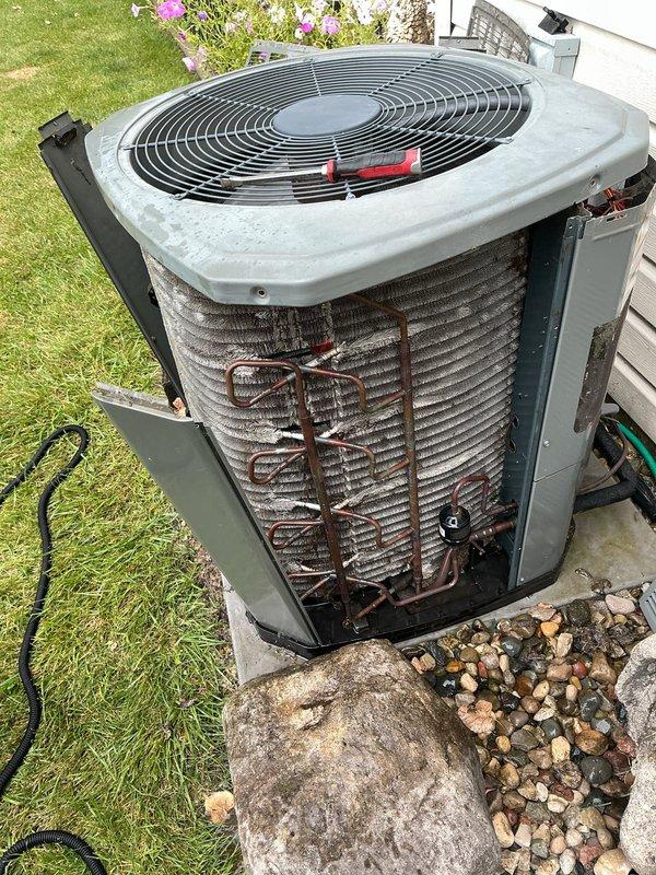 Completed first annual air conditioning maintenance visit on residential cooling system. Performed comprehensive inspection of outdoor condenser unit, including visual examination of condenser coils which showed moderate dirt and debris accumulation between aluminum fins. Assessed refrigerant lines, electrical connections, and fan assembly operation. Unit was found operational with normal wear consistent with outdoor exposure. Documented equipment condition through photographic records showing condenser coils, fan guard assembly, and overall unit placement on concrete pad with proper drainage pan installed.