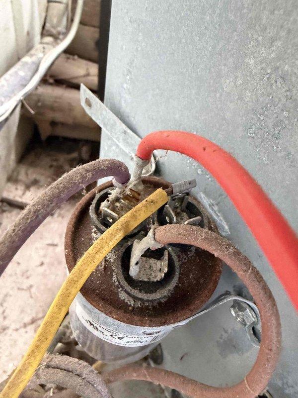 Completed prepaid cooling maintenance visit on residential HVAC system. Upon inspection, discovered severely rusted capacitor with deteriorated wiring connections and corroded electrical terminal block with multiple discolored brass screws showing signs of age and oxidation. Documented equipment condition with photographs for maintenance records. System components exhibited extensive environmental exposure and corrosion requiring attention for continued safe operation.