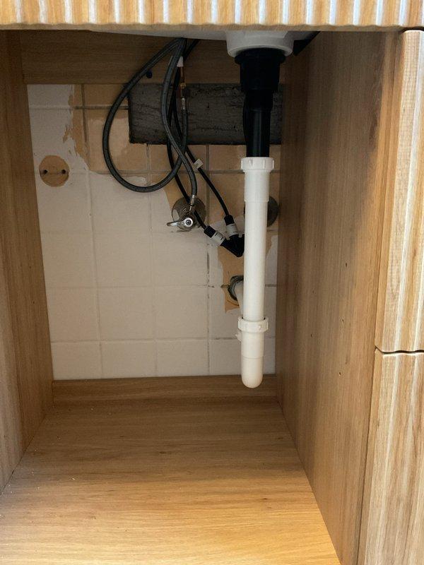 Installed customer-provided dual-flush button mechanism on toilet tank, replacing existing flush lever system. Verified proper operation of flush mechanism and confirmed watertight seal on tank lid assembly. Under-sink plumbing and garbage disposal connections inspected and confirmed to be functioning properly with no leaks detected.