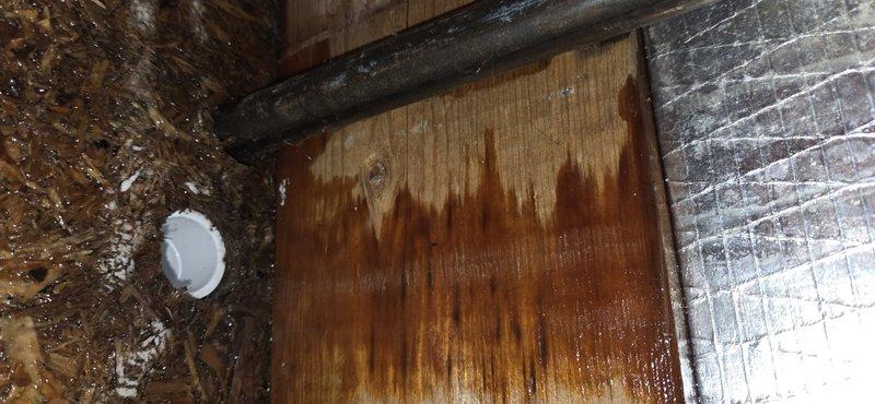 Responded to urgent no-cool call on recently installed AC unit and discovered missing condensate drain line, causing four months of continuous water discharge into crawlspace. Documented extensive water damage including flooded crawlspace, warped and sinking bedroom floor, and severe moisture staining on wooden subfloor and structural components. Photographed water damage patterns on plywood decking showing vertical streaking and discoloration from prolonged moisture exposure, deteriorated composite materials, and affected areas near HVAC ductwork and insulation. Identified improperly installed air conditioning system lacking required primary drain line, resulting in catastrophic water intrusion and compromised structural integrity. Assessed cooling performance concerns in addition to water damage remediation needs.