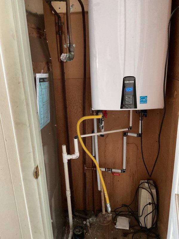 Responded to water leak call involving copper supply line located behind Navien tankless water heater. Upon arrival, inspected the mechanical closet and identified the leaking copper line in proximity to the water heater installation. Documented existing conditions with photographs showing the tankless unit, associated plumbing connections including copper piping, PVC drainage lines, and yellow flexible gas line. Assessed the leak location and surrounding plumbing infrastructure to determine appropriate repair approach and provided customer with findings and recommended next steps for resolution.