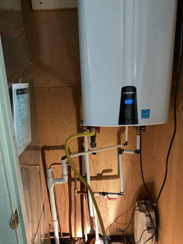 Responded to water leak call involving copper supply line located behind Navien tankless water heater. Upon arrival, inspected the mechanical closet and identified the leaking copper line in proximity to the water heater installation. Documented existing conditions with photographs showing the tankless unit, associated plumbing connections including copper piping, PVC drainage lines, and yellow flexible gas line. Assessed the leak location and surrounding plumbing infrastructure to determine appropriate repair approach and provided customer with findings and recommended next steps for resolution.
