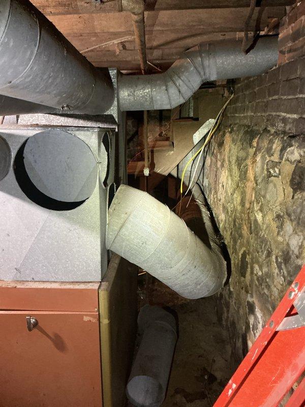 Conducted comprehensive assessment of aging gas furnace system in residential basement for replacement estimate. Evaluated existing HVAC infrastructure including deteriorated galvanized ductwork, exposed foundation conditions with moisture damage and efflorescence on masonry walls, and current furnace cabinet configuration. Documented system layout, duct connections, and structural considerations for furnace replacement recommendation.