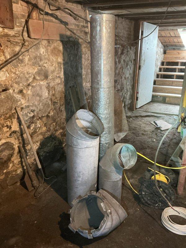 Conducted comprehensive assessment of aging gas furnace system in residential basement for replacement estimate. Evaluated existing HVAC infrastructure including deteriorated galvanized ductwork, exposed foundation conditions with moisture damage and efflorescence on masonry walls, and current furnace cabinet configuration. Documented system layout, duct connections, and structural considerations for furnace replacement recommendation.