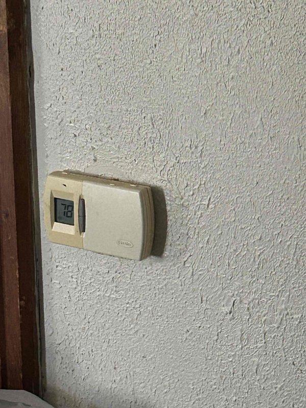 Conducted follow-up site assessment for full HVAC system replacement after previously quoting air conditioning unit only. Documented existing thermostat configuration and electrical service panel with proper circuit breaker arrangement to ensure compatibility with proposed heating and cooling equipment installation.