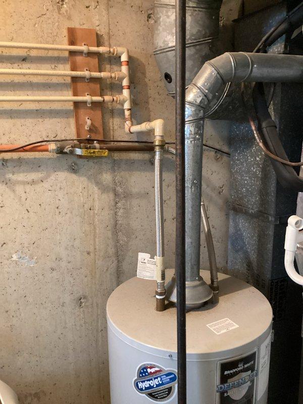 Replaced failed 40-gallon natural gas water heater in basement mechanical room due to active leak. Installed new unit elevated on 3-inch PVC couplings to raise equipment off concrete floor for improved drainage and code compliance. Added thermal expansion tank to system to protect against pressure buildup and extend equipment lifespan. Reconnected all water supply lines, gas line, and flue venting to manufacturer specifications, ensuring proper draft and combustion safety.