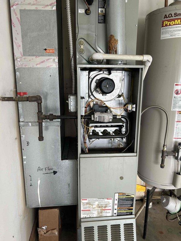 Completed HVAC system assessment for equipment replacement estimate. Evaluated existing gas furnace, air handler with ductwork configuration, and accompanying water heater installation in mechanical room. Documented current system components including Honeywell digital thermostat, blower motor assembly, electrical controls, rigid and flexible ductwork with proper airflow directional markings, gas lines, and plumbing connections to provide comprehensive replacement recommendations.