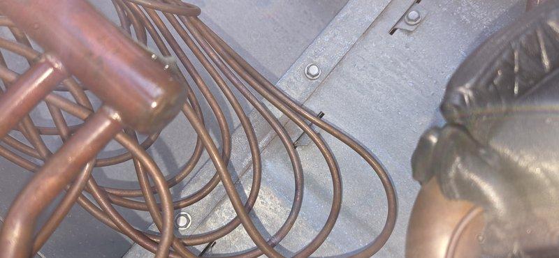 Responded to no cooling call on Carrier rooftop unit model 48TCEM16A45A00000 serving showroom area. Upon inspection, documented equipment nameplate information and examined refrigerant coil assembly with copper tubing loops and heat exchanger components. Unit assessed and customer contacted regarding findings.