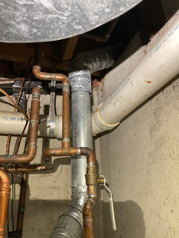 Responded to inspection report callback for plumbing installation review. Upon arrival, inspected water heater connections and associated piping system in basement utility area. Verified proper installation of mixed copper and PVC piping configuration, including galvanized vertical supply lines with appropriate condensation management. Examined all pipe joints, elbows, and fittings for proper connection integrity. Confirmed UL-listed coupling components were correctly installed per manufacturer specifications. Checked mounting brackets securing horizontal PVC runs to ensure adequate support. Inspected copper pipe connections to water heater with brass fittings, verifying proper solder joints and no signs of leakage. Documented all plumbing connections, pipe materials, and installation methods with photographs for inspection compliance records. All components found to be properly installed with correct materials and meeting current plumbing code requirements.
