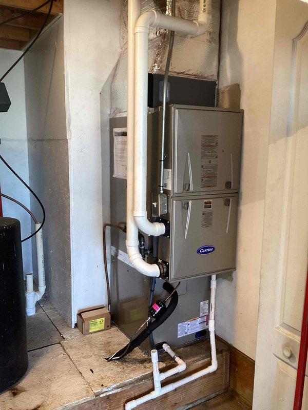 Completed full HVAC system replacement in residential basement, installing new Carrier brand furnace unit with associated ductwork and ventilation components. Installed PVC condensate drainage and venting piping system with proper routing throughout the utility space. Connected new air conditioning coil to furnace unit and established refrigerant lines to outdoor condensing unit. Upgraded thermostat to digital Honeywell programmable unit, mounted in main living area and wired to new equipment. Verified all electrical connections at furnace disconnect panel, tested system operation across heating and cooling modes, and confirmed proper airflow through supply and return ductwork.