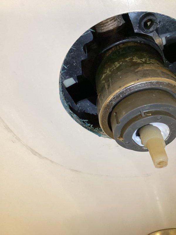 Responded to upstairs shower leak complaint. Accessed shower valve assembly through wall opening to address leaking fixture that customer was unable to disassemble. Removed corroded trim cover and escutcheon displaying significant oxidation and mineral buildup. Replaced internal valve cartridge components with customer-supplied parts. Reassembled fixture with proper sealing to prevent further water intrusion into wall cavity.