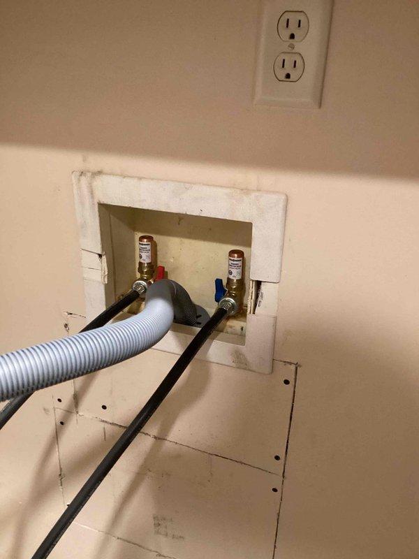 Responded to service call for corroded washing machine hookup faucets requiring replacement. Upon inspection, found significant corrosion and oxidation on copper supply lines and shut-off valves with deteriorated finish on hot and cold water connections. Removed section of drywall to access plumbing system behind washer box. Assessed extent of corrosion on copper piping throughout wall cavity. Replaced corroded washing machine shut-off valves with new hot and cold water supply valves. Installed new flexible supply hoses to washer box connections. Verified all connections for proper operation and absence of leaks. Documented existing plumbing conditions with photos showing before and during repair stages.