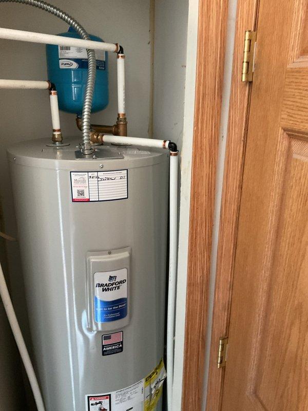 Installed a Bradford White 50-gallon electric water heater (Model RE250T6-1NCWW) with expansion tank and completed necessary electrical connections. The unit was installed in a utility closet with proper PVC piping, brass fittings, pressure relief valve, and flexible connector lines, with the blue expansion tank mounted to the wall above the water heater.