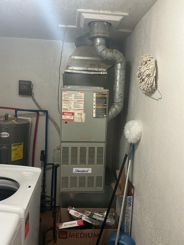 Conducted comprehensive assessment of existing 22-year-old Standard brand gas furnace for complete HVAC system replacement estimate. Property currently relies on window air conditioning unit with no central cooling system installed. Evaluated mechanical room conditions, existing ductwork configuration, thermostat wiring, and utility connections to determine specifications for new gas furnace and air conditioning system installation. Documented equipment model information, electrical requirements, and noted environmental concerns including active wasp nest in mechanical space requiring remediation prior to installation.