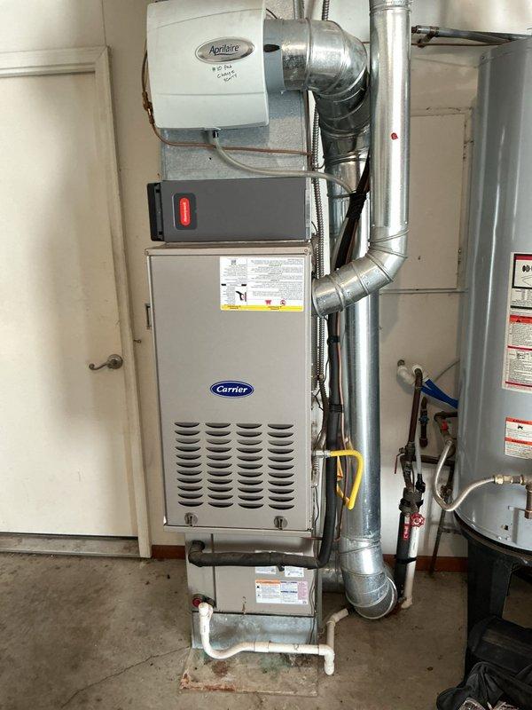 Completed routine heating maintenance on a 7-year-old Carrier furnace located in garage utility room. Performed comprehensive system inspection including burner assembly, heat exchanger, blower motor, and all safety controls. Replaced air filter per customer request, retrieving new filter from storage box on freezer. Verified proper operation of Aprilaire humidifier integrated with system. Checked gas pressure, tested ignition sequence, and confirmed adequate airflow throughout ductwork. All components operating within manufacturer specifications with no deficiencies noted. System running efficiently and ready for heating season.