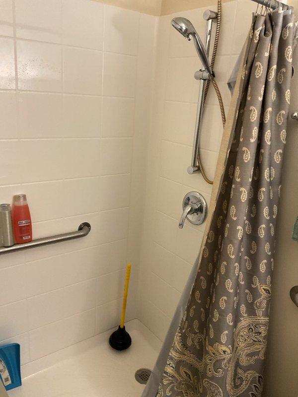 Completed on-site assessment for conversion of existing walk-in shower to tub-shower combination unit. Evaluated current accessibility features including grab bars, shower chair placement, and handheld shower fixture configuration. Documented existing white subway tile surround, chrome fixtures, and shower pan dimensions to provide accurate estimate for fixture replacement and necessary plumbing modifications.