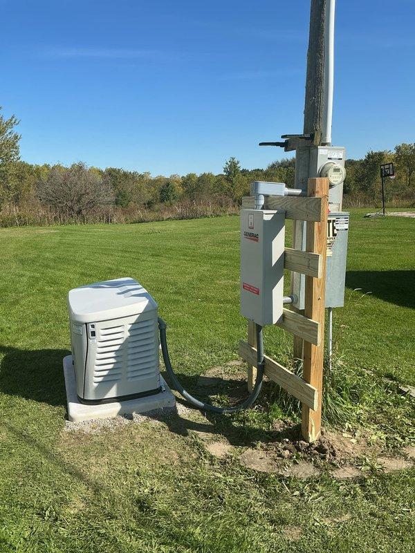 Completed installation of 24KW Generac generator system with 200-amp automatic transfer switch at residential property. Constructed custom treated lumber support structure adjacent to existing meter pole to mount ATS panel, ensuring proper elevation and secure attachment. Built treated wood frame foundation for generator pad and filled with gravel to raise unit above low-grade terrain, preventing potential water intrusion. Installed electrical conduit and wiring connections between generator, ATS, and main service panel. Verified proper leveling of all equipment and tested system functionality upon completion.