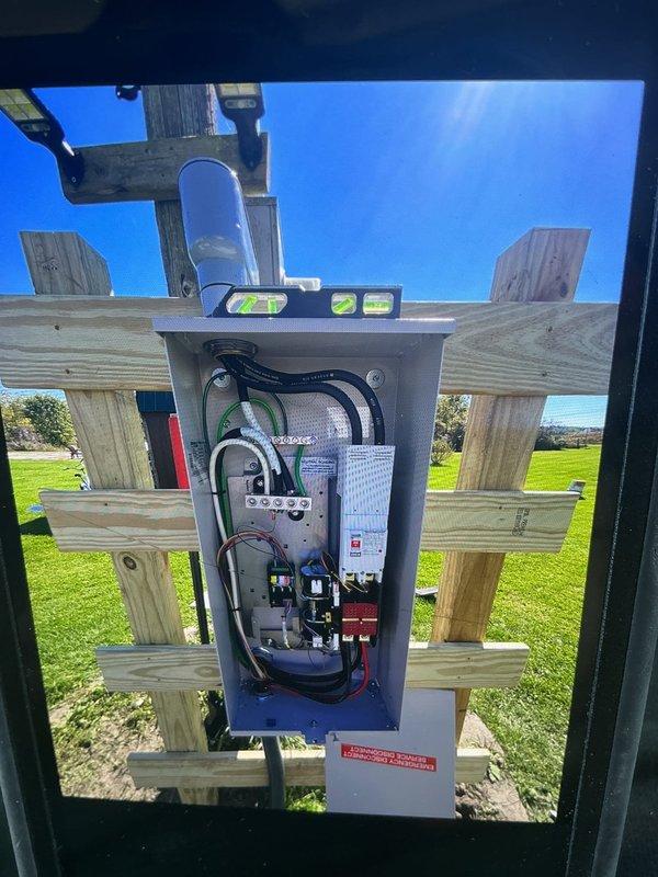 Completed installation of 24KW Generac generator system with 200-amp automatic transfer switch at residential property. Constructed custom treated lumber support structure adjacent to existing meter pole to mount ATS panel, ensuring proper elevation and secure attachment. Built treated wood frame foundation for generator pad and filled with gravel to raise unit above low-grade terrain, preventing potential water intrusion. Installed electrical conduit and wiring connections between generator, ATS, and main service panel. Verified proper leveling of all equipment and tested system functionality upon completion.
