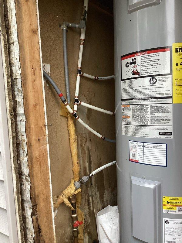 Completed water heater installation in residential utility space with copper and PEX piping connections. Identified piping configuration in water heater area requiring modification and scheduled return visit to redo plumbing work to ensure proper system operation and code compliance.