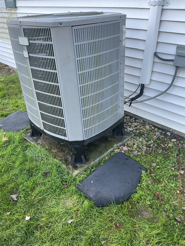 Completed follow-up service call to install stabilizing support pads beneath heat pump condenser unit. Positioned and leveled black composite equipment pads on ground surface to provide proper foundation and prevent settling. Unit now sits securely on upgraded pad system, ensuring stable operation and proper drainage around equipment.