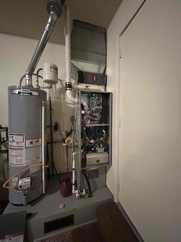Conducted comprehensive assessment of existing HVAC system and water heating equipment in residential mechanical room for replacement estimate. Documented current furnace unit with exposed internal components, including control boards, wiring configurations, and mechanical assemblies, noting accessibility through front service panel. Evaluated existing ductwork connections, including metallic flex duct and plenum integration with ceiling-mounted air handler. Assessed water heater installation with copper piping connections, pressure relief valve configuration, and PVC venting system. Photographed equipment layout, spatial constraints, and existing utility connections to provide accurate replacement specifications and installation requirements for customer consideration.