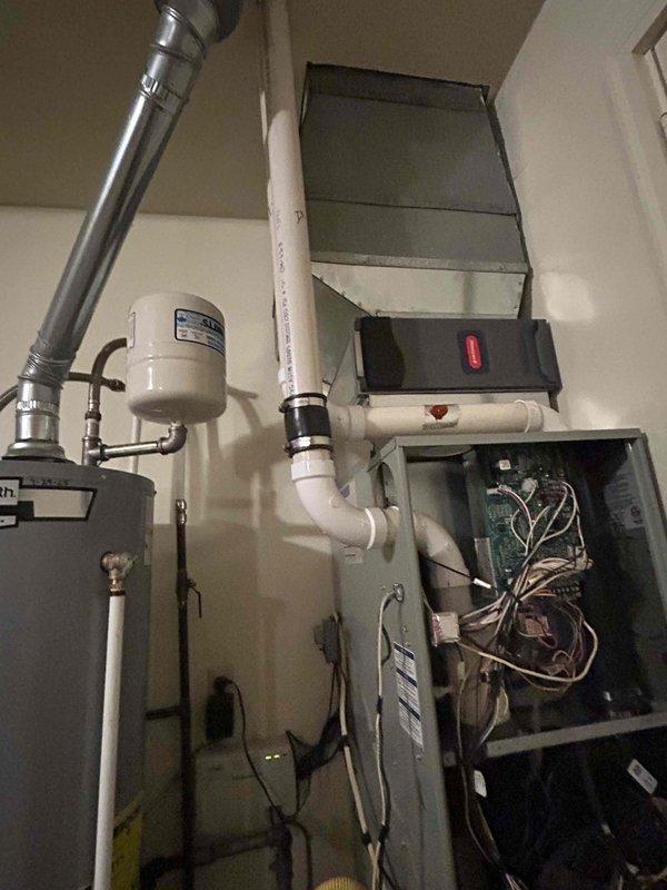 Conducted comprehensive assessment of existing HVAC system and water heating equipment in residential mechanical room for replacement estimate. Documented current furnace unit with exposed internal components, including control boards, wiring configurations, and mechanical assemblies, noting accessibility through front service panel. Evaluated existing ductwork connections, including metallic flex duct and plenum integration with ceiling-mounted air handler. Assessed water heater installation with copper piping connections, pressure relief valve configuration, and PVC venting system. Photographed equipment layout, spatial constraints, and existing utility connections to provide accurate replacement specifications and installation requirements for customer consideration.