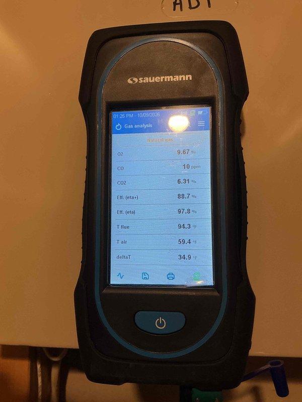 Completed first prepaid heating maintenance visit during scheduled morning appointment window. Performed comprehensive combustion analysis on heating system using calibrated gas analyzer, recording optimal operational parameters including oxygen levels at 9.67%, carbon monoxide at safe 10 ppm, carbon dioxide at 6.31%, with gross efficiency at 88.7% and net efficiency at 97.8%. Flue temperature measured at 94.3°F with ambient air temperature at 59.4°F, yielding acceptable temperature differential of 34.9°F. Documented existing water softener system and associated plumbing infrastructure in mechanical space. All heating system measurements indicate proper combustion and efficient operation within manufacturer specifications.