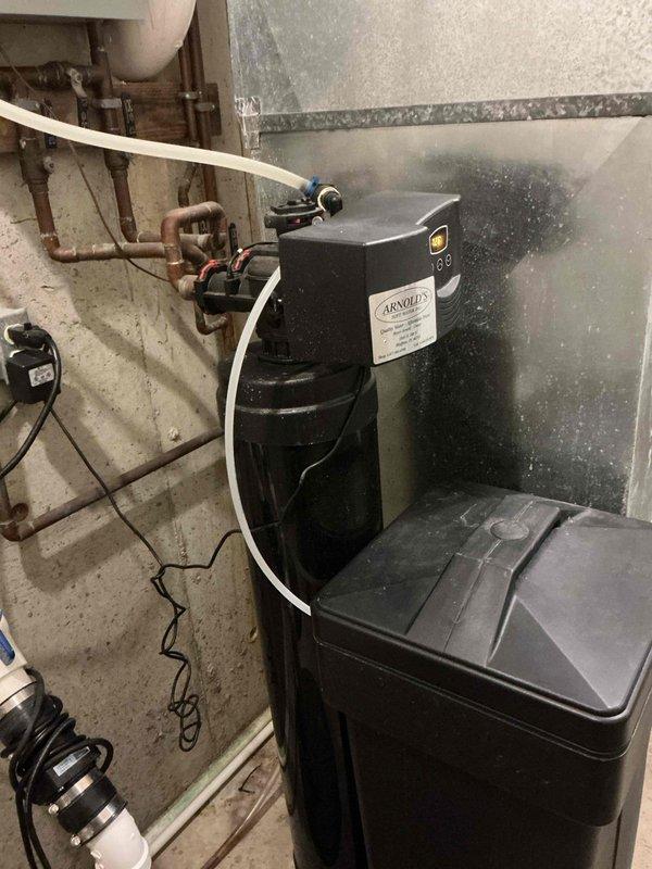 Completed first prepaid heating maintenance visit during scheduled morning appointment window. Performed comprehensive combustion analysis on heating system using calibrated gas analyzer, recording optimal operational parameters including oxygen levels at 9.67%, carbon monoxide at safe 10 ppm, carbon dioxide at 6.31%, with gross efficiency at 88.7% and net efficiency at 97.8%. Flue temperature measured at 94.3°F with ambient air temperature at 59.4°F, yielding acceptable temperature differential of 34.9°F. Documented existing water softener system and associated plumbing infrastructure in mechanical space. All heating system measurements indicate proper combustion and efficient operation within manufacturer specifications.