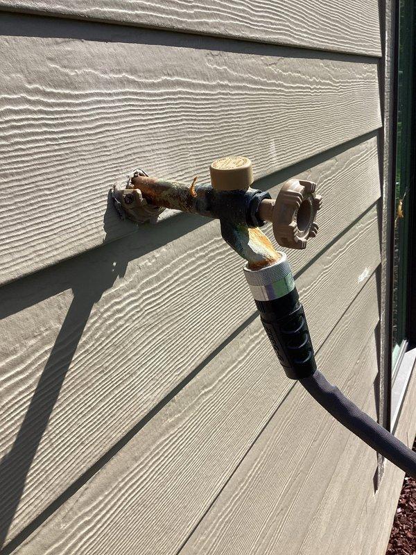 Conducted on-site evaluation of two exterior hose bibs requiring replacement. First fixture exhibited structural failure with the valve assembly separating from the wall mounting, compromising water control and creating potential for water intrusion into the building envelope. Second hose bib was frozen and inoperable, likely due to internal ice damage from inadequate winterization or failed freeze protection. Documented existing conditions through photographic evidence showing weathered brass components, oxidized valve bodies, and current installation configuration on horizontal vinyl siding. Assessment included evaluation of supply line accessibility, mounting substrate condition, and determination of replacement specifications needed to restore proper function and prevent future freeze damage.