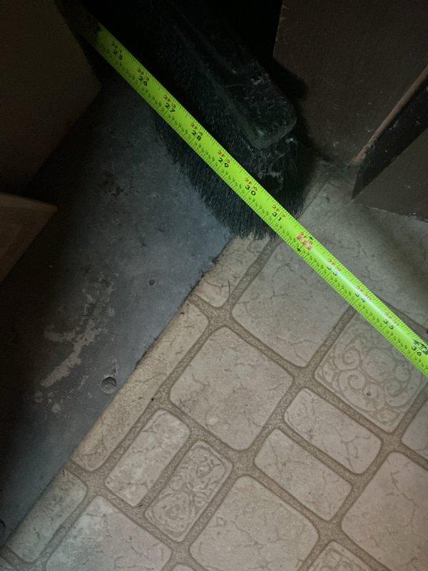 Performed an on-site evaluation for a full HVAC system replacement, including measuring the air handler cabinet and filter section dimensions and inspecting the existing pleated filter and insulated panel, which showed dust accumulation and frayed insulation at the edges. Also took clearance measurements of the surrounding floor space, which includes vinyl tile and a rough concrete surface, to confirm equipment fit and installation requirements for the new system quote.