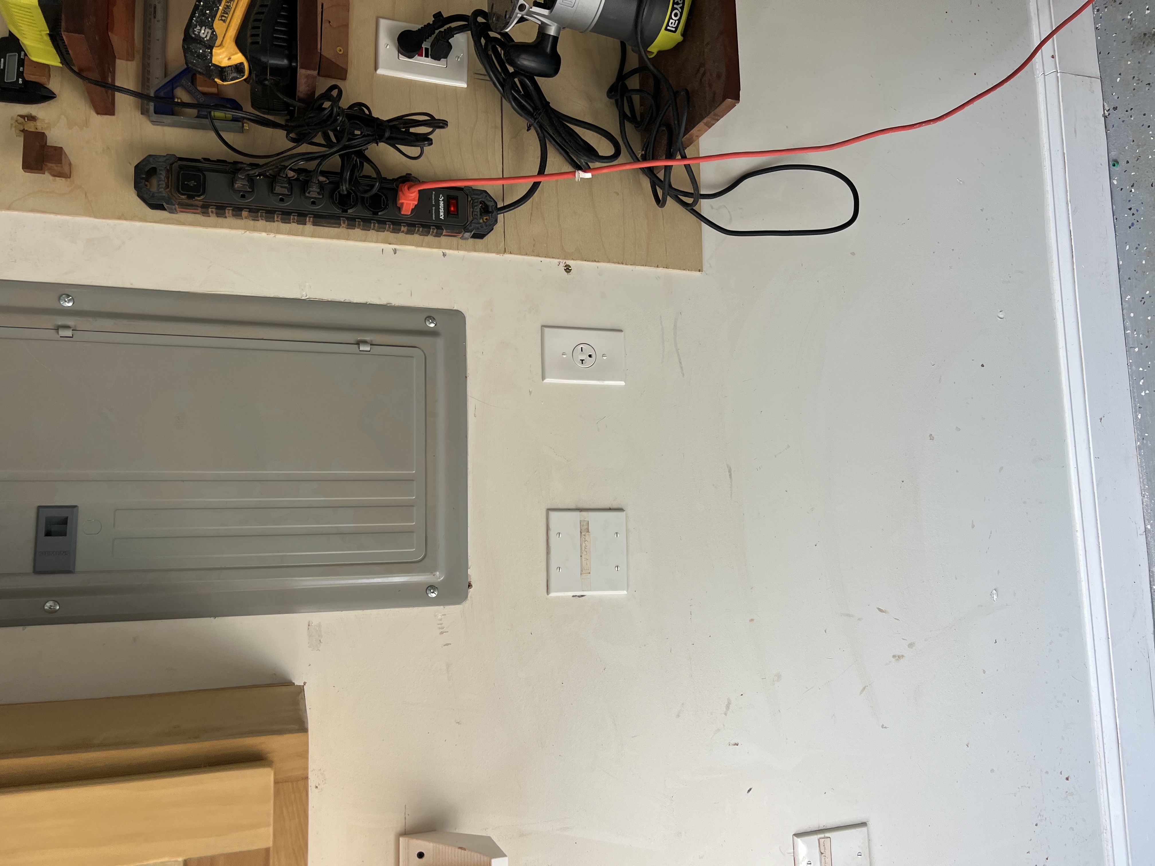 Today, I installed a dedicated receptacle for the customer’s bandsaw and extended power to a surface-mounted box for a garden/security camera light. The bandsaw receptacle was installed directly below the existing electrical panel, with wiring extended from a GFCI-protected receptacle on the back wall of the garage. During the inspection, I identified damage on the electrical panel’s bus bar, consistent with a power surge or possible lightning strike. Due to this, I recommend replacing the existing panel and all breakers with a new 42/64-space panel. The customer plans to revisit the panel replacement after their upcoming trip.