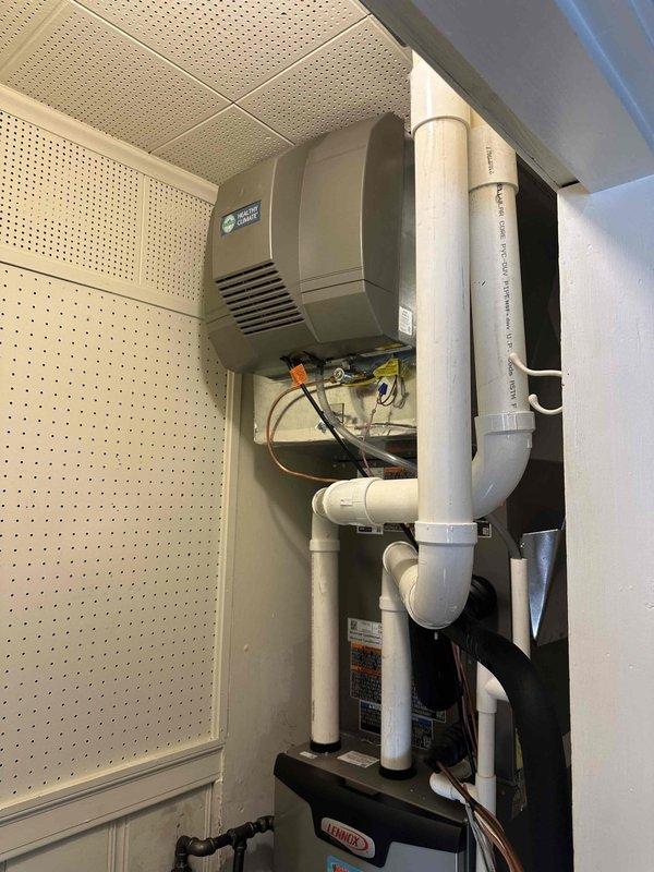 Completed installation of customer-supplied powered humidifier. Work included cutting wall access opening to connect copper water supply line to the humidifier, installing water shutoff valve with PVC drainage, and mounting the ventilation unit with proper PVC drain line configuration. System was tested and confirmed operational.