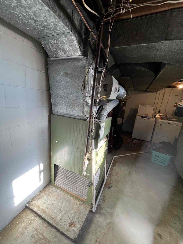 Conducted estimate for replacement of aging furnace system in basement utility area. Current installation includes older olive green furnace unit with galvanized metal ductwork connecting to ceiling distribution system. Recommended upgrading to higher efficiency equipment while utilizing existing duct infrastructure where possible.