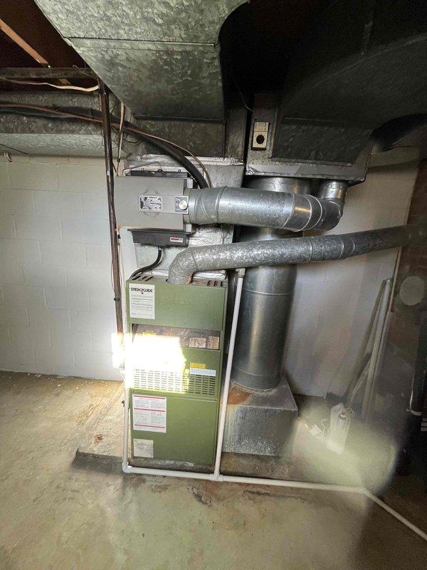 Conducted estimate for replacement of aging furnace system in basement utility area. Current installation includes older olive green furnace unit with galvanized metal ductwork connecting to ceiling distribution system. Recommended upgrading to higher efficiency equipment while utilizing existing duct infrastructure where possible.