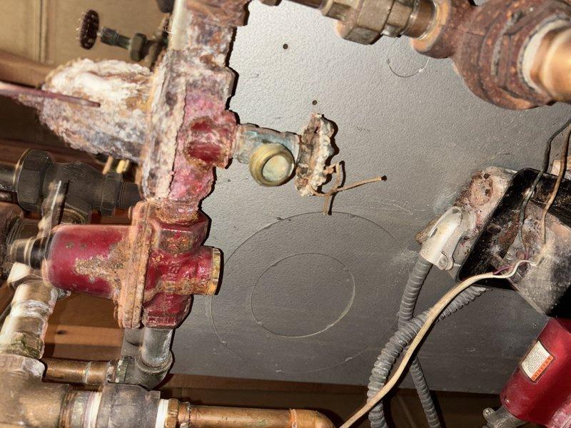 Diagnosed and replaced failed circulator pump motor on 20+ year old boiler system that was preventing hot water distribution through the heating system. Visual inspection revealed extensive corrosion and mineral buildup on multiple valves and pipe connections throughout the system. Recommended customer consider system replacement due to advanced deterioration and multiple components nearing end of service life.