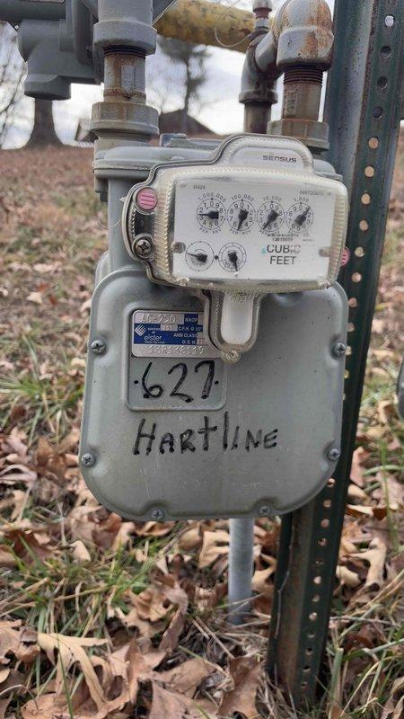Completed site evaluation for generator installation at the Hartline residence. Inspected existing gas meter and surrounding utility area, noting meter condition and current gas service capacity. Assessed available space beneath deck structure for potential generator placement, documenting existing utility pipes that would require consideration during installation. Photos taken of gas meter and under-deck area to assist in determining appropriate generator specifications based on client's request for options below 24kW.