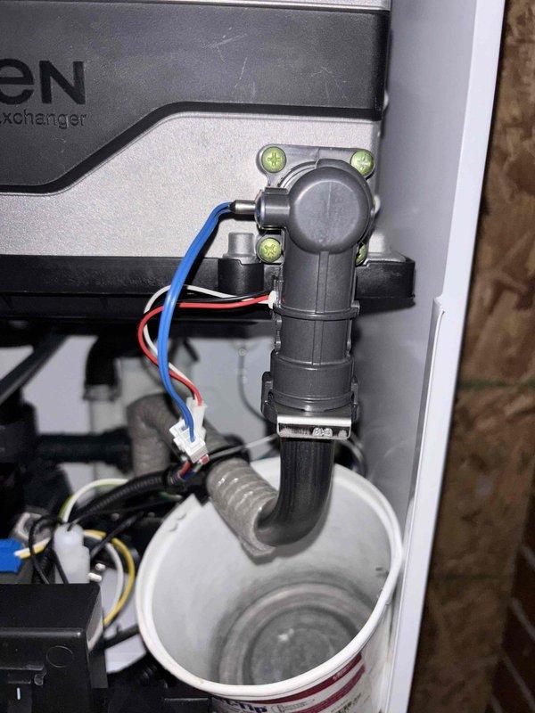 Inspected water heater system following complaint of leakage. Verified customer report of tank leaking in two distinct areas as noted by Brent. Documented issues with detailed photographs of the heat exchanger system, condensate drain assembly, and associated plumbing components. Observed PVC drain pipe configuration and electrical connections to determine proper remediation steps for the leaking tank.