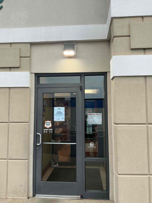 Conducted follow-up inspection of exterior lighting at commercial property. Verified proper functioning of entry door illumination and wall-mounted LED floodlight. All lighting fixtures operating as expected with appropriate coverage of entrance and building perimeter.