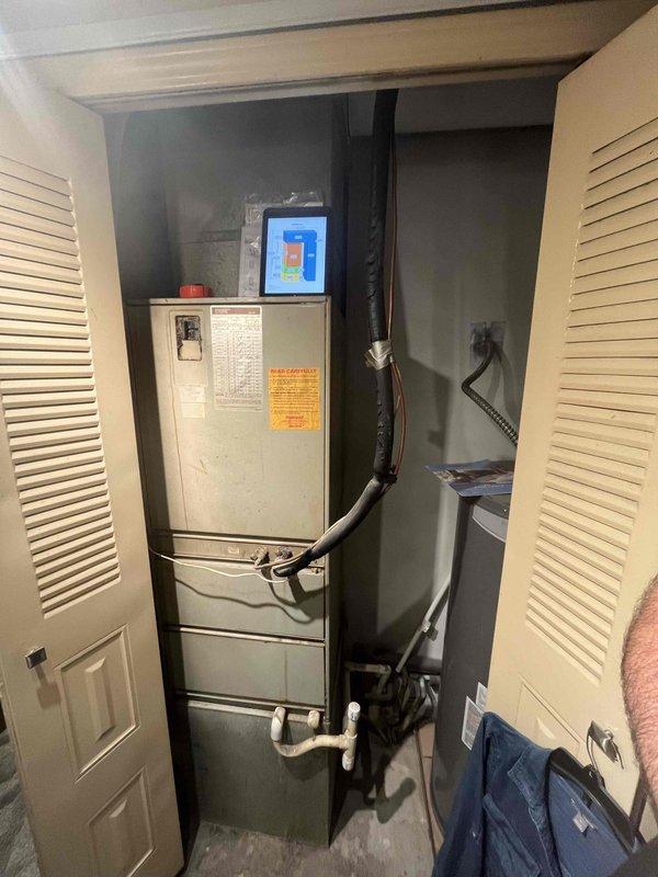 Performed inspection of existing electric heat pump system located in utility closet with louvered door access. System is serving a small-to-mid sized home (1001-1599 sq.ft.). Documented condition of air handler unit, ductwork connections, and examined air filter which showed significant pleating wear. Customer is interested in full heating and cooling system replacement options.