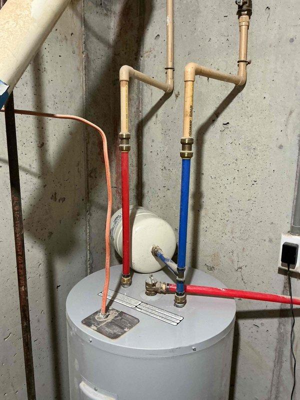 Conducted estimate for a 40-gallon electric water heater replacement, discussing tankless options and gas line extension possibilities as requested by homeowner. Current installation features standard electric water heater with PVC piping system, proper hot/cold water lines, and expansion tank all in good working condition. Presented options for both electric replacement and conversion to gas, including requirements for running gas line to current installation location.