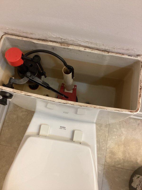 Responded to customer concern regarding two slow-flushing toilets. Performed visual inspection of both TOTO toilets, revealing mineral buildup and scale deposits within the tanks, affecting the flush valve assemblies. Snaked both toilets to clear any blockages and restore proper water flow and drainage function. Both units now flushing properly at normal speed.