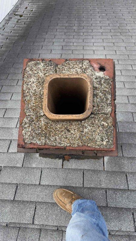 Performed roof inspection to assess rerouting options for 80% furnace and water heater currently vented through deteriorating chimney. Documented measurements and evaluated structural integrity of existing terracotta flue liner and masonry base, which showed significant weathering and debris accumulation. Confirmed customer's concerns about potential aesthetic and safety issues with proposed 12ft roof penetration alternative.