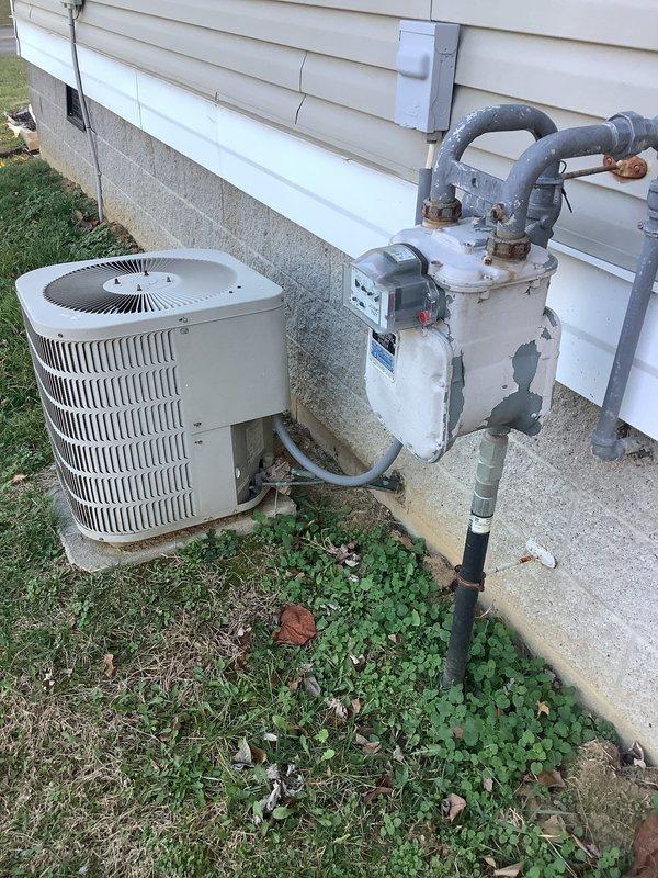Conducted a comprehensive replacement estimate for an aging HVAC system including furnace and AC condenser unit. Customer inquired about bundling options with tankless water heater installation and requested detailed warranty information. Visual inspection revealed weathered outdoor condenser on concrete pad with deteriorating gas meter/regulator connections and an older model furnace in need of replacement.