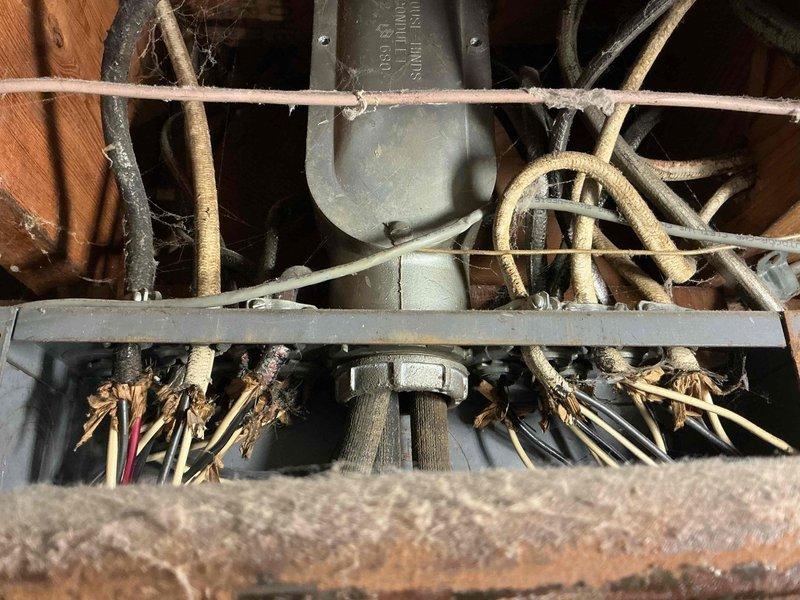 Conducted follow-up inspection of electrical panel as requested by Dave B. Documented significant issues including aged wiring with discoloration, disorganized wire arrangement not meeting current standards, and proximity to severely corroded copper piping. Photos taken revealed deteriorated electrical connections with exposed/fraying wire ends in confined space, indicating urgent need for system upgrade to address safety concerns.
