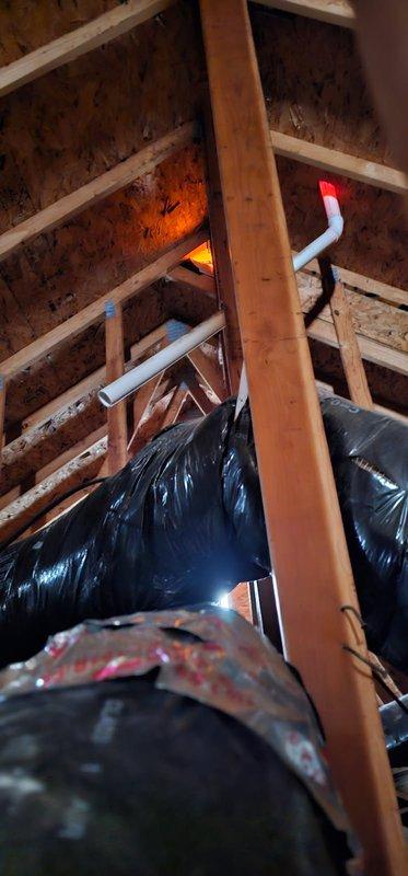 Conducted follow-up inspection of previously rerun exhaust system after customer reported water leakage into attic from cut PVC pipe left during initial service. Visual examination of the attic space confirmed presence of disconnected PVC pipe sections near the black insulated ductwork, resulting in condensation accumulation. Properly sealed and reconnected the PVC pipe to eliminate the leak source.